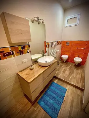 a bathroom with a sink and a toilet and a mirror at Casa Batù alle porte del Capo in Palermo