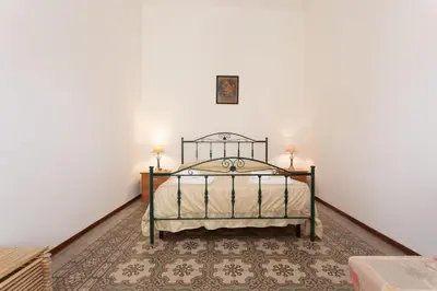 a bedroom with a bed in a white wall at GuestHost - Castellammare Stella Apartments in Castellammare del Golfo