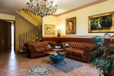 a living room with brown leather couches and a chandelier at Bed And Breakfast Marina d'Aspra in Bagheria