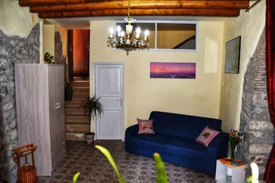 a living room with a blue couch and a chandelier at L' Arco Antico in Caccamo