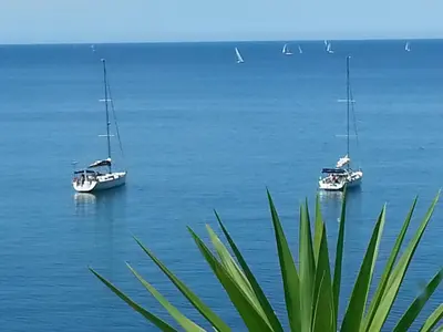 two boats floating on the water with sailboats at Vero Sicily - Villa Acqua Chiara in Bagheria