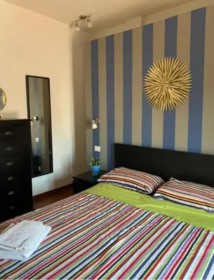 a bedroom with a bed with a colorful striped wall at MONTE PELLEGRINO HOUSE AND TERRACE in Palermo