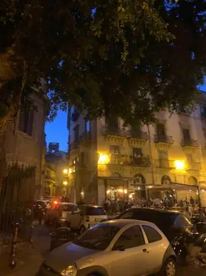 a white car parked on a city street at night at Appartamento NA ME CASA in Palermo