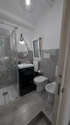a bathroom with a toilet and a sink and a shower at Loft Pozzillo in Monreale