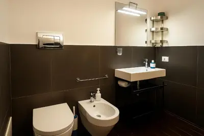 a bathroom with a white toilet and a sink at La Residenza dell' Alloro in Palermo