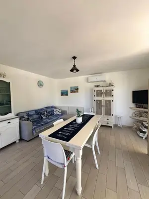 a living room with a table and a bed at Marilù Casa Vacanza in San Vito lo Capo