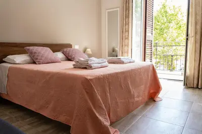 a bedroom with a bed with pink sheets and a window at Gennaro Holidays in Corleone
