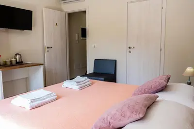 a bedroom with a pink bed with a chair at Gennaro Holidays in Corleone