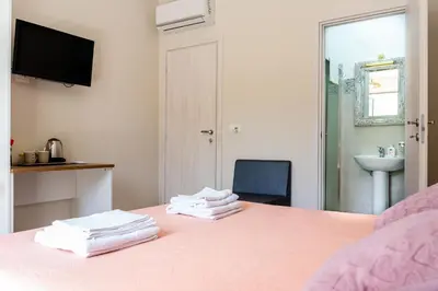 a bedroom with a pink bed with towels on it at Gennaro Holidays in Corleone