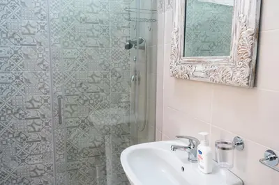 a bathroom with a sink and a shower with a mirror at Gennaro Holidays in Corleone