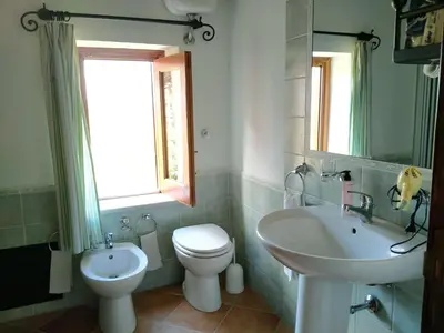 a bathroom with a toilet and a sink and a mirror at Villa Paladino Solunto in Santa Flavia