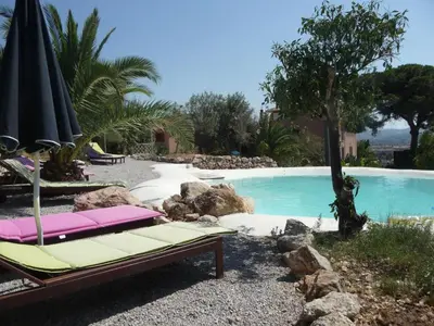 a swimming pool with two lounge chairs and an umbrella at Villa Paladino Solunto in Santa Flavia