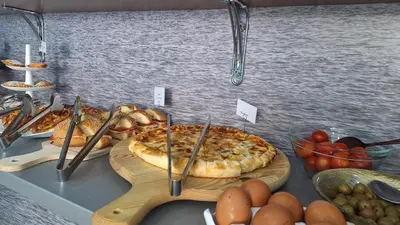 a table with a pizza and other food on it at B&B A Mare in Castellammare del Golfo