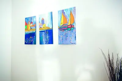 four paintings of a sailboat on a wall at B&B A Mare in Castellammare del Golfo