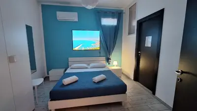 a blue bedroom with a bed with two pillows at B&B A Mare in Castellammare del Golfo