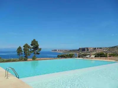a swimming pool with a view of the ocean at Makari Bay Home in San Vito lo Capo