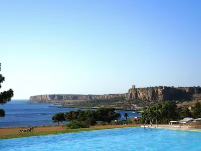 a pool with a view of the ocean and cliffs at Makari Bay Home in San Vito lo Capo