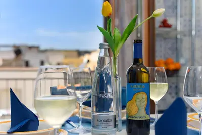 a table with wine glasses and a bottle of wine at Appartamento Dolceluna in San Vito lo Capo