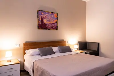 a bedroom with a bed and a painting on the wall at Gennaro Holidays Appartament in Corleone