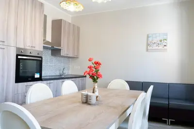 a kitchen with a wooden table with a vase of flowers on it at Gennaro Holidays Appartament in Corleone
