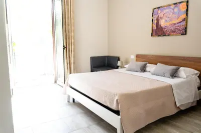 a bedroom with a large bed and a chair at Gennaro Holidays Appartament in Corleone