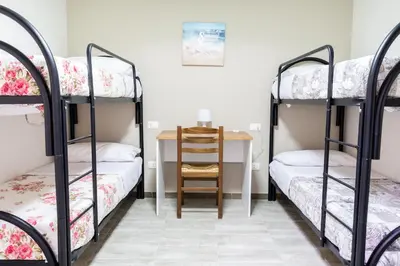 a room with three bunk beds and a desk at Gennaro Holidays Appartament in Corleone