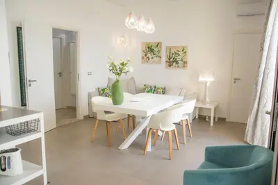 a white dining room with a white table and chairs at La Villa di Nonna Pina in Balestrate