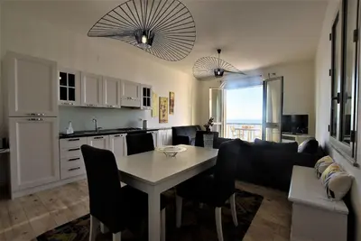 a kitchen and living room with a table and chairs at La Villa di Nonna Pina in Balestrate