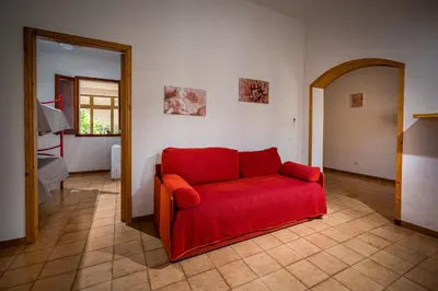 a red couch sitting in a living room at La Casetta in San Vito lo Capo