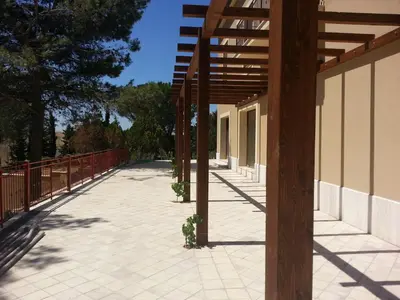 a patio with a fence and a wooden pergola at Feudo Del Biviere in Santa Ninfa