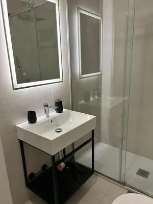 a white bathroom with a sink and a shower at MARGOT HOUSE PALERMO in Palermo