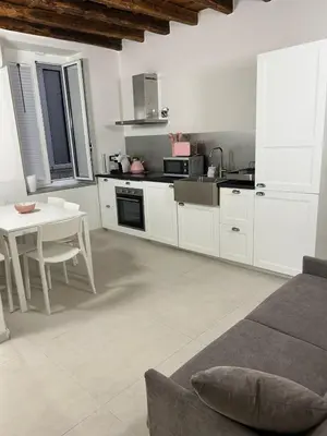 a kitchen with white cabinets and a table and a table and a table at MARGOT HOUSE PALERMO in Palermo