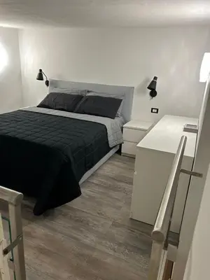 a bedroom with a bed with a black blanket at MARGOT HOUSE PALERMO in Palermo