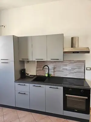 a kitchen with white cabinets and a black sink at Simone Cupolas View in Palermo
