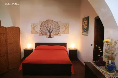 a bedroom with a red bed with two lights on it at Baglio 
