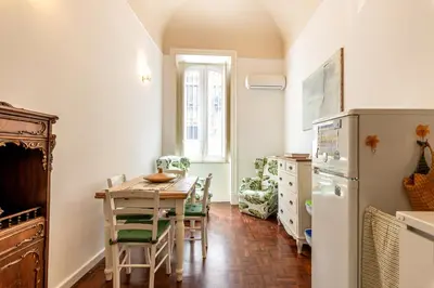 a kitchen with a table and chairs and a refrigerator at Casa Goethe delle Volte by Wonderful Italy in Palermo