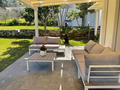 a patio with two couches and a coffee table at Villa Oasi Verde in Cinisi