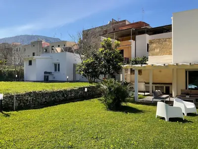 a yard with white chairs and a building at Villa Oasi Verde in Cinisi