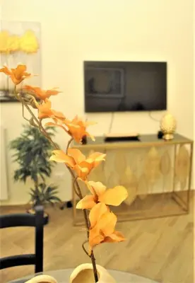 a vase with orange flowers in a living room at TALO' - casa vacanze in Palermo