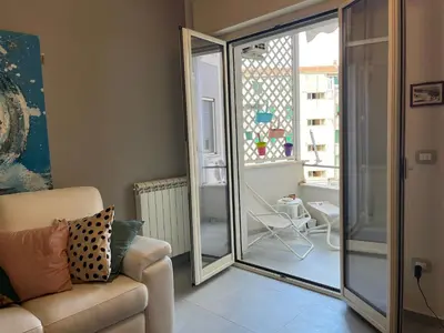 a living room with a couch and a sliding glass door at Wave house in Palermo