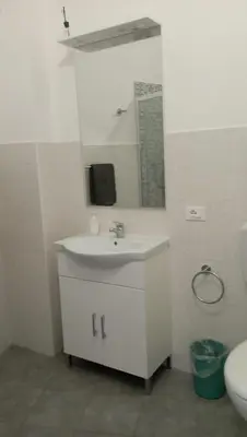 a bathroom with a sink and a mirror and a toilet at Serradifalco Cozy House di Enza e Luigi in Palermo