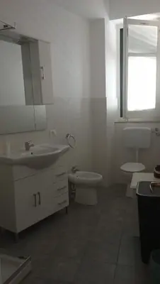 a bathroom with a sink and a toilet and a mirror at Serradifalco Cozy House di Enza e Luigi in Palermo