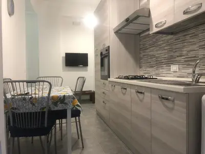 a kitchen with a table and a stove top oven at Serradifalco Cozy House di Enza e Luigi in Palermo