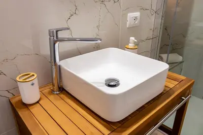 a white sink on a wooden counter in a bathroom at Daria's home apartment rooms in Palermo