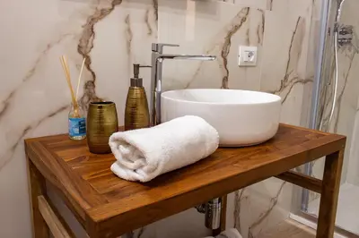 a bathroom with a sink on a wooden table at Daria's home apartment rooms in Palermo