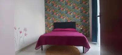 a bedroom with a purple bed with a floral wallpaper at Alloggio Garibaldi in Palermo