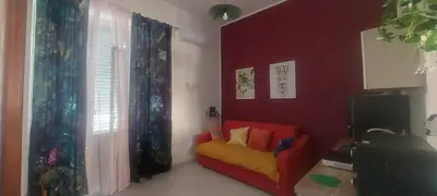 a living room with a yellow chair and a red wall at Alloggio Garibaldi in Palermo