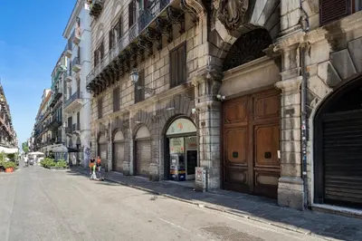 a person riding a bike on a street next to a building at Little House Mavi by DomuSicily in Palermo