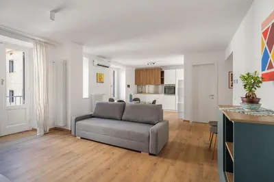 a living room with a couch and a kitchen at Little House Mavi by DomuSicily in Palermo