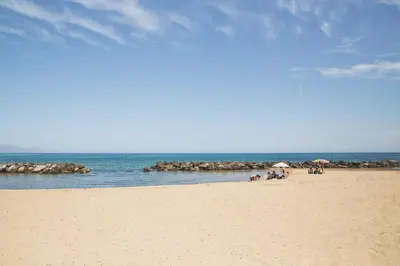 a group of people sitting on a beach with umbrellas at Villa sulla spiaggia Riva Estate by Le Dhome Sicily in Trappeto